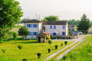 a house with blue windows in a green field at B&B Lilla All'Adige in Legnago
