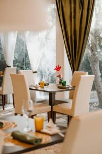 a dining room with a table and chairs and a window at Villa Ceci Dimora di Storie in Andria