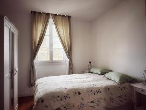 a bedroom with a bed and a window at Le Chalet du 1er étage, Appartement de charme de 80m2, 2 chambres in Bagnoles de l'Orne