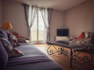 a living room with a couch and a table at Le Chalet du 1er étage, Appartement de charme de 80m2, 2 chambres in Bagnoles de l'Orne