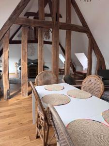 a dining room with a white table and chairs at Maison Popeline in Les Andelys +23 photos
