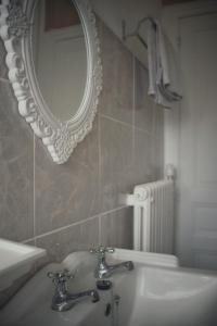 a bathroom with a sink and a mirror and a radiator at Le Chalet du 1er étage, Appartement de charme de 80m2, 2 chambres in Bagnoles de l'Orne +21 photos