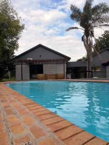a swimming pool in front of a house at 101 Marais Villa in Hartbeespoort
