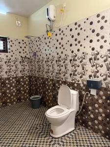 a bathroom with a white toilet in a room at Mud apples in Varkala