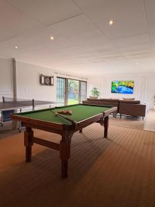 a living room with a pool table and a couch at 101 Marais Villa in Hartbeespoort