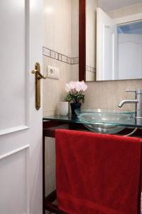 a bathroom with a glass sink and a red towel at Cosy and Secure Suite Marbella Center in Marbella
