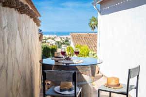 a table and chairs on a balcony with wine glasses at The Denia Hideaway in Denia