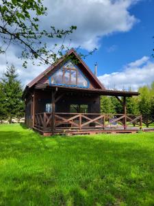 a house with a large window on a green field at Siedlisko Ptasie Trele 2 in Jerutki