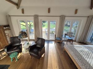 a bedroom with a bed and two chairs and a table at Pré du Tour in Érezée