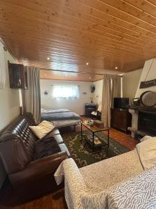 a living room with a leather couch and a table at Casa do Vale - Seixas in Caminha