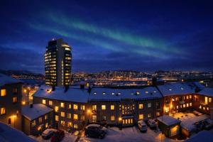 a building at night with snow on the roofs at Studio 28 in Narvik