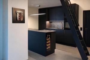 a kitchen with a blue island with a wine cellar at Studio 28 in Narvik +7 photos