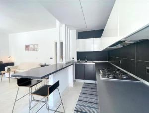 a kitchen with black and white cabinets and a stove at Anzio lighthouse terrace family-group friendly in Anzio