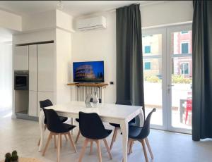 a dining room with a white table and chairs at Anzio lighthouse terrace family-group friendly in Anzio