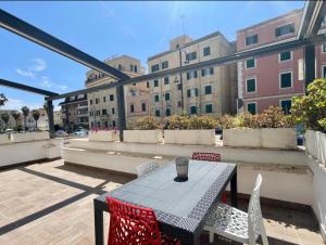 a patio with a table and chairs on a balcony at Anzio lighthouse terrace family-group friendly in Anzio