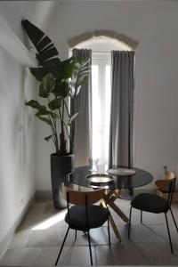 a dining room with a table and chairs and a plant at RODRIGUEZ Luxury Suite in Ostuni