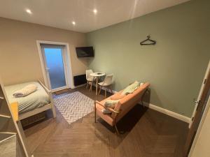 a bedroom with a bed and a couch and a table at 1 double bed studio with private access and parking in Plymouth