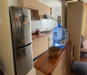 a kitchen with a bottle of water next to a refrigerator at Departamento familiar in La Serena