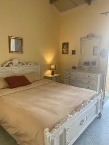 a bedroom with a white bed with a dresser and a mirror at Siciliana in Caronia