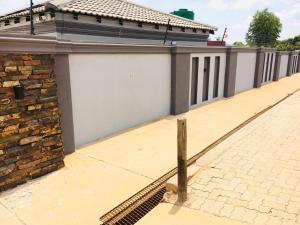 a building with a white garage and a brick sidewalk at Miaz Palace in Elim