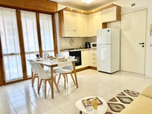 a kitchen with a table and a white refrigerator at La casa di AngeLis in Stezzano