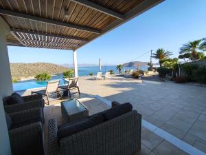 a patio with a view of the ocean at Villa Tholos Crete in Kavoúsion