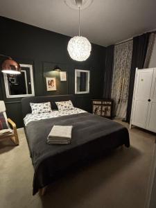 a bedroom with a large bed and a chandelier at Petite Charlotte in Tarnów