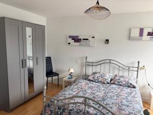 a bedroom with a bed and a chair and a lamp at Abéane in Châtel-Guyon