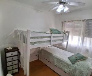 a bedroom with a white bunk bed and a ceiling fan at Celestia in Punta del Este