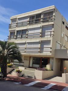 a building with a palm tree in front of it at Celestia in Punta del Este