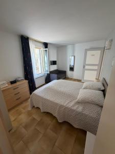 a bedroom with a bed and a dresser and window at Les Remparts T2 et T3 2 Etoiles in La Roche-Posay