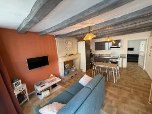 a living room with a blue couch and a kitchen at Les Remparts T2 et T3 2 Etoiles in La Roche-Posay