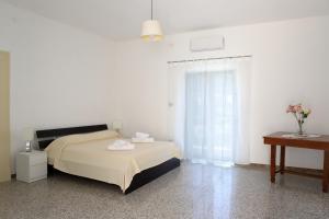 a white bedroom with a bed and a table and a desk at Gragnano in in Gragnano