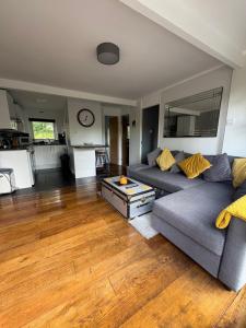 a living room with a couch and a table at Tree Top View Chalet in Caeathro