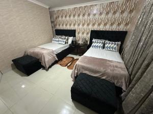 a bedroom with two beds and a table at Cactus Village in Blantyre