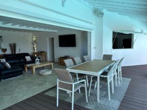 a living room with a wooden table and chairs at Domaine Madinina Dream in Sainte-Luce
