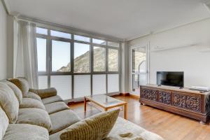 a living room with a couch and a tv at Orio Playa in Orio