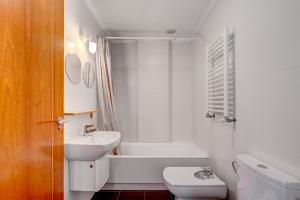 a bathroom with a sink and a tub and a toilet at Orio Playa in Orio +19 photos