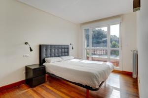 a bedroom with a bed and a large window at Orio Playa in Orio