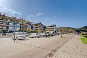 a city street with cars parked in a parking lot at Orio Playa in Orio