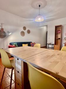 ein Esszimmer mit einem großen Holztisch und gelben Stühlen in der Unterkunft Escape House in Almograve