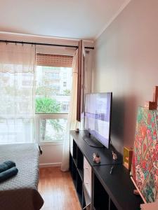 a bedroom with a television and a bed and a window at Apparemment agréable in Levallois-Perret