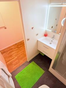 a bathroom with a sink and a green rug at Apparemment agréable in Levallois-Perret