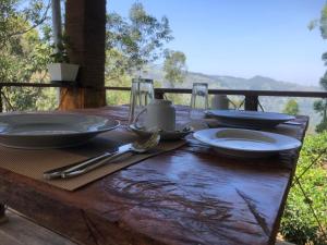 a wooden table with plates and utensils on it at Ella 96TN Resort in Ella +41 photos