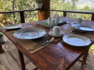a wooden table with plates and utensils on it at Ella 96TN Resort in Ella
