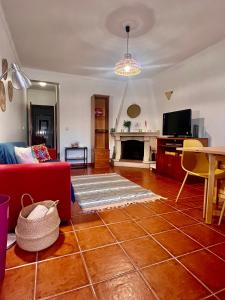 ein Wohnzimmer mit einem roten Sofa und einem Kamin in der Unterkunft Escape House in Almograve