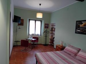 a bedroom with a bed and a table and a window at Ca' melindetta in Recetto