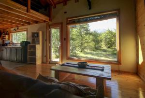 a living room with a table and a large window at Piedra Nevada in Malalcahuello