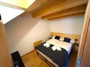 a bedroom with a bed with two towels on it at Dolomiti Panorama - 3 Rooms in Carano +19 photos