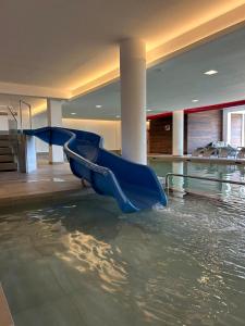 a slide in a pool of water in a building at Dolomiti Panorama - 3 Rooms in Carano
